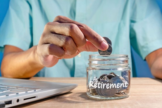 man putting coins into a jar that say retirement