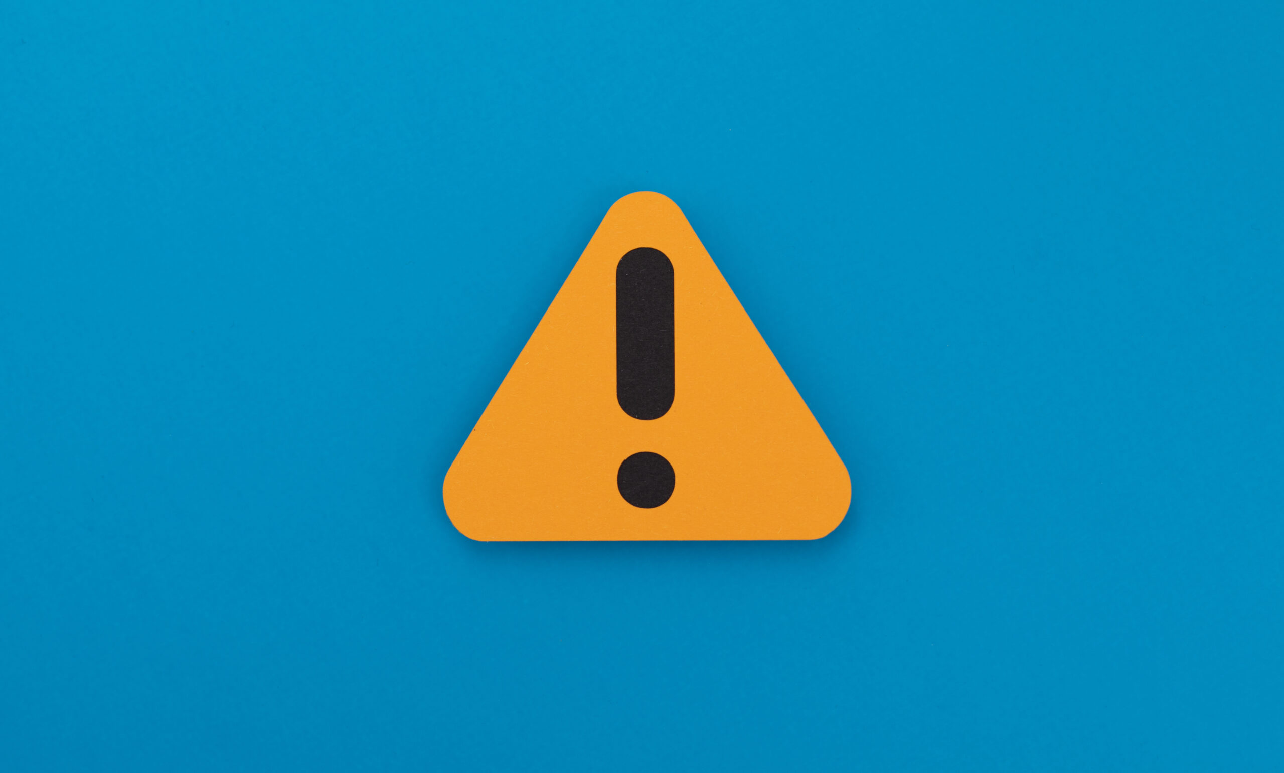 Warning sign on a blue background, indicating caution or alertness.