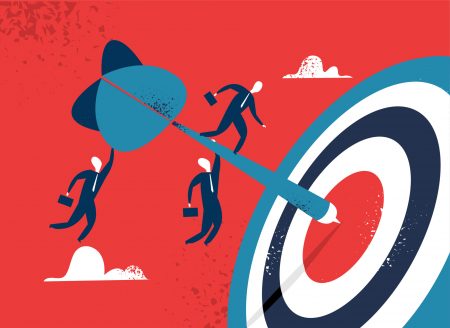 Business people pushing a target into the center of a larger target against a red background.