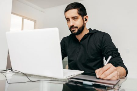 Designer working from home using laptop and tablet.