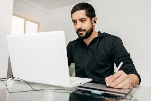 Designer working from home using laptop and tablet.