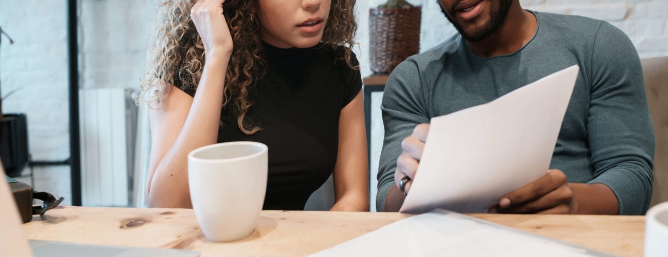 Young couple calculating and paying bills on a laptop from home. Couple planning monthly budget.
