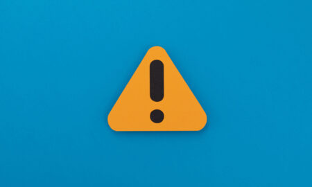 Warning sign on a blue background, indicating caution or alertness.