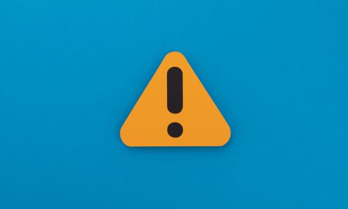 Warning sign on a blue background, indicating caution or alertness.