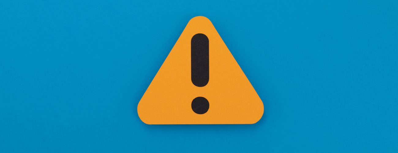 Warning sign on a blue background, indicating caution or alertness.