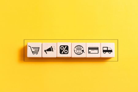 A wooden block featuring icons that represent the concept of ecommerce, prominently displaying the word "ecommerce."