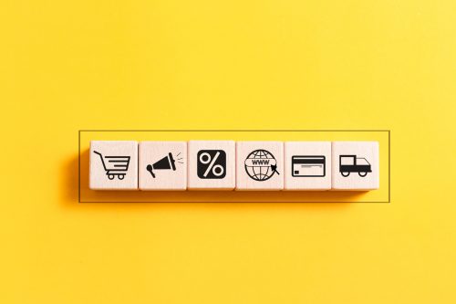 A wooden block featuring icons that represent the concept of ecommerce, prominently displaying the word "ecommerce."