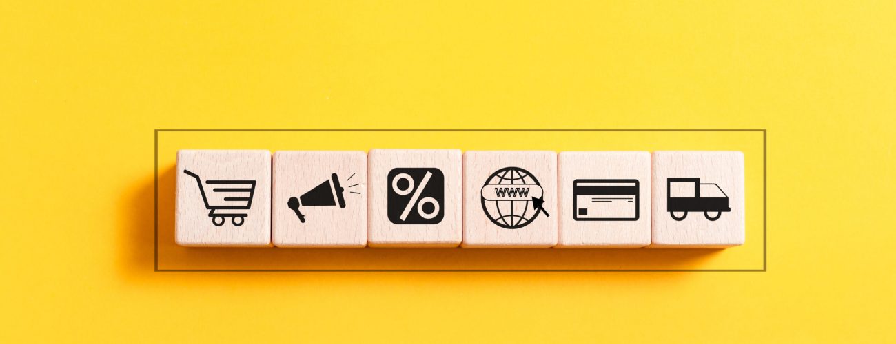 A wooden block featuring icons that represent the concept of ecommerce, prominently displaying the word "ecommerce."