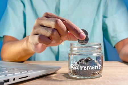 man putting coins into a jar that say retirement