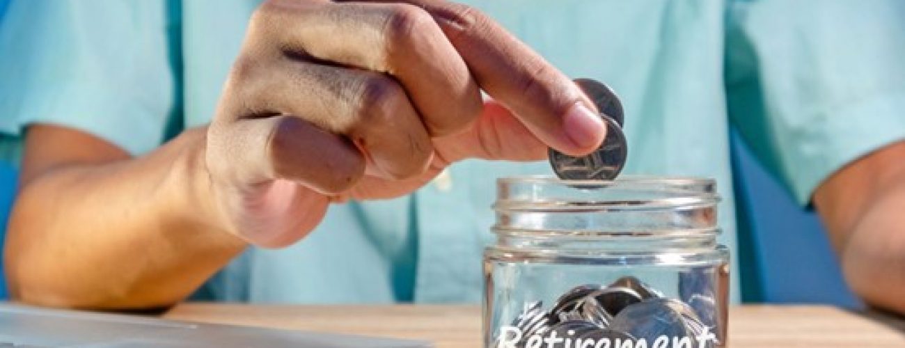 man putting coins into a jar that say retirement