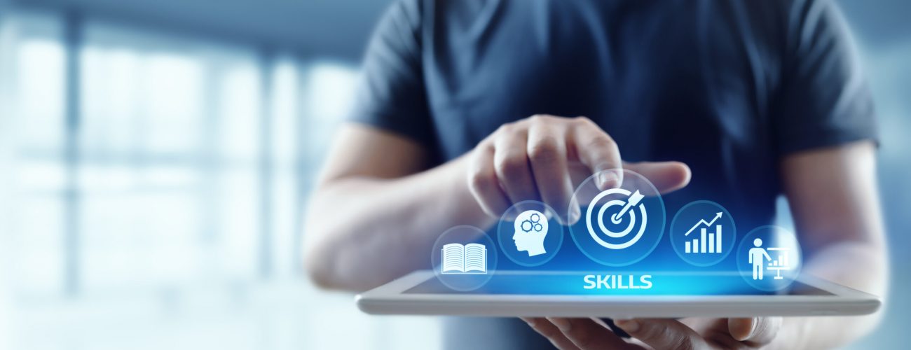 a man is standing with an ipad that has icons and he is pointing to one of them