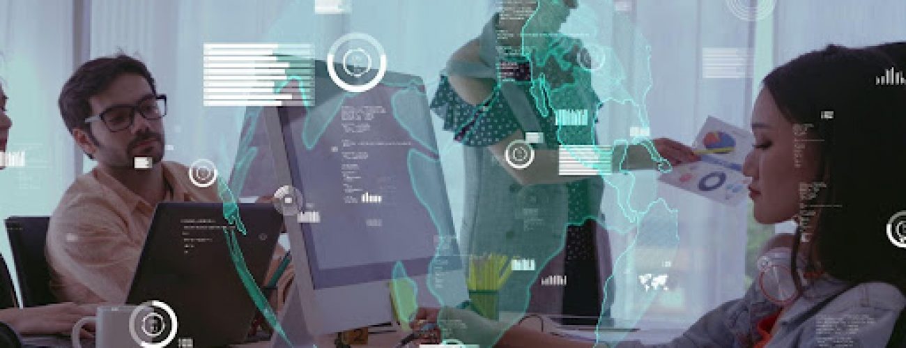 People collaborating at desks with computers in a modern office environment.